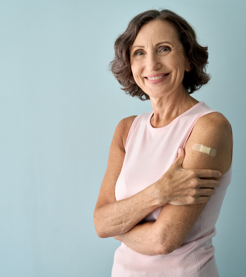 Lady smiling with her sleeve rolled up showing a bandage on her arm