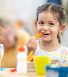 Little girl eating a carrot 