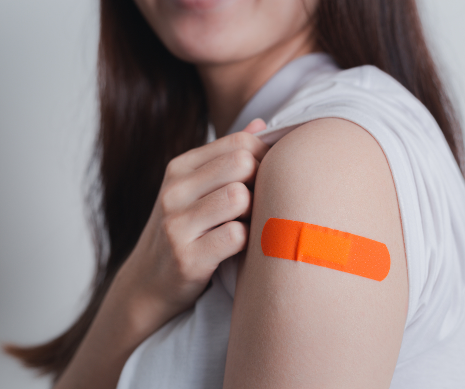 close up of young woman with orange bandage on her arm