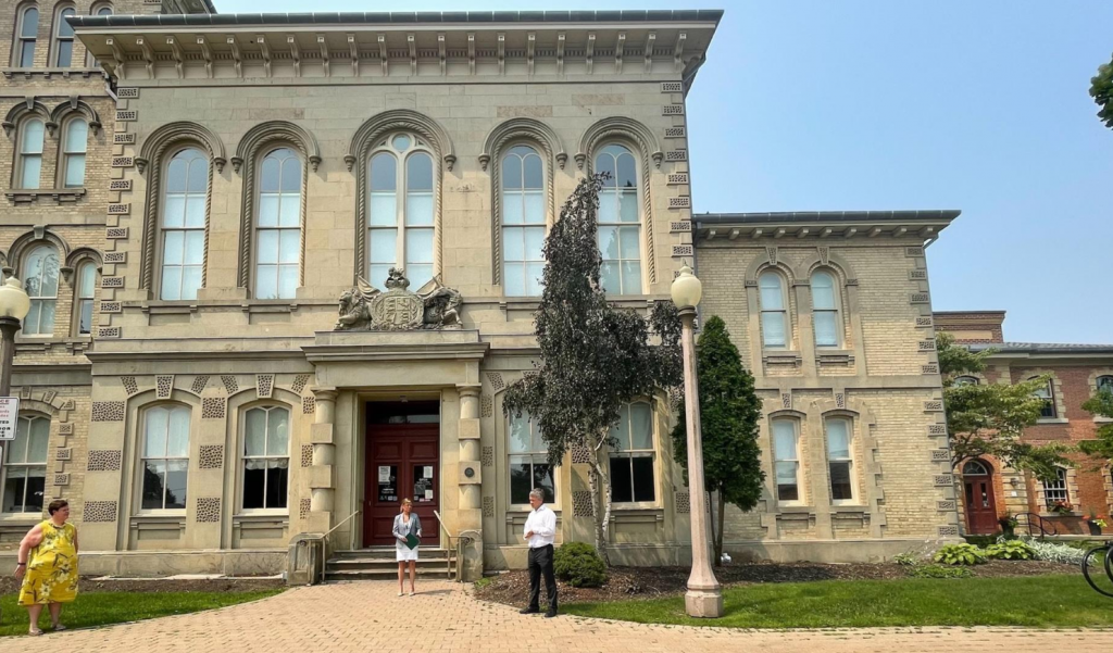 Haldimand-Norfolk Board of Health Chair Kristal Chopp stands in front of the Norfolk County Administration Building with Bill Cridland, General Manager, Operations (Norfolk County) and Heidy Van Dyk, Acting General Manager, Health and Social Services. 