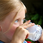 young girl drinking a glass of milk